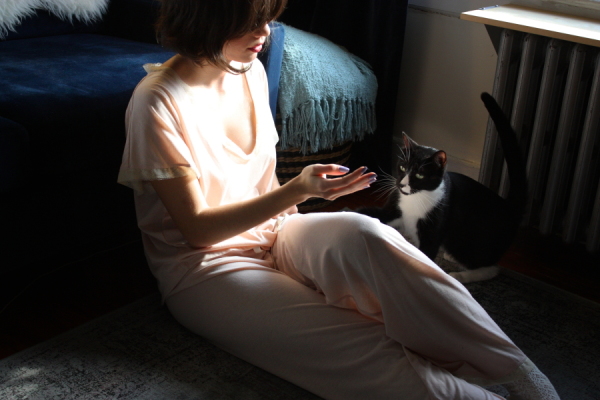 girl playing with cat in pajamas