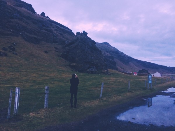 arden leigh taking a photo of hillside cottage - between the sheets iceland travel tips